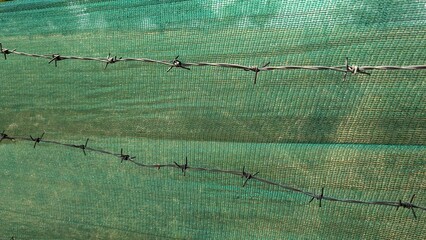 Durable Green Protective Netting Combined with Strong Barbed Wire for Enhanced Security
