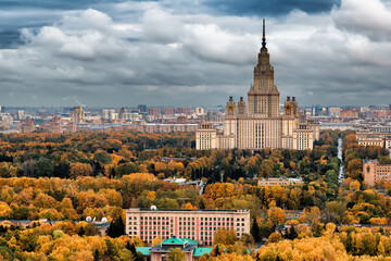 Moscow, Russia - 05 September 2021: View of the majestic Moscow State University rising above a sea of autumnal trees under a cloudy sky.