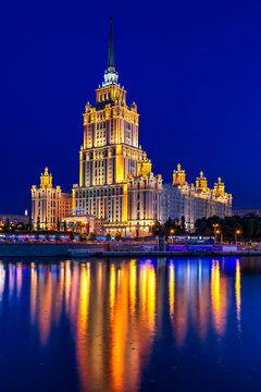 Moscow, Russia - 23 July 2025: View of the Radisson Collection Hotel, its golden lights mirrored in the tranquil, dark waters of the Moskva River.