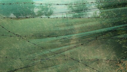 Fence made of shading mesh and barbed wire