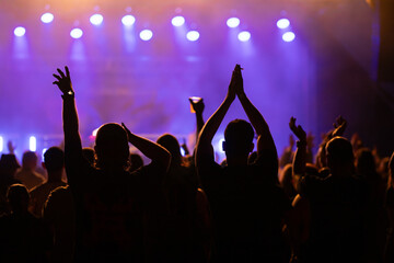 Crowd at concert and blurred stage lights.