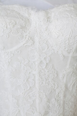 Obraz premium White lace wedding dress with intricate floral embroidery on display for bridal enthusiasts