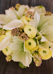 Fototapeta premium Elegant bouquet of pale flowers with yellow ranunculus and lilies arranged for a spring celebration in a rustic setting