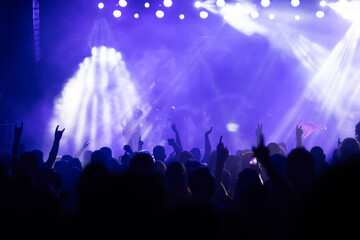 Crowd at concert and colorful stage lights.