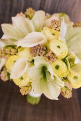 Elegant floral bouquet featuring yellow roses, calla lilies, and green buds arranged for a special occasion