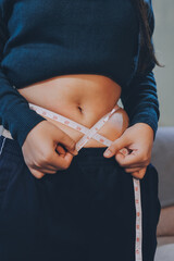 woman's hand holding excessive belly fat, overweight concept