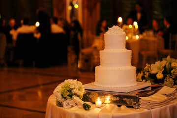 Elegant wedding cake on a beautifully decorated table at a romantic evening reception