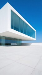 Obraz premium Modern minimalist building with large glass windows under a clear blue sky
