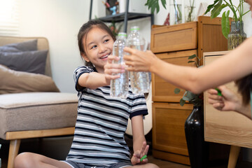 Mother and daughter sharing water bottles in a cozy living room