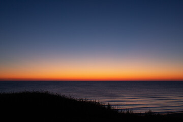 The smooth red horizon of the sea at dawn.