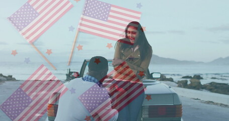 Kneeling man proposing to smiling woman on convertible trunk at coastal road, rocky shoreline