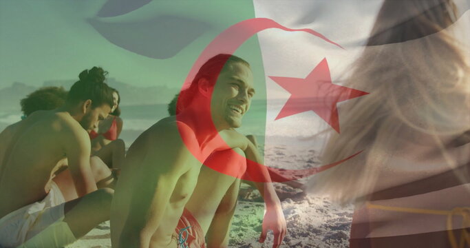 Chatting man wearing red swim trunks with friends on sandy beach, with red crescent flag overlay - Powered by Adobe