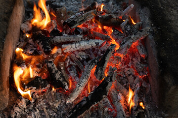 Burning coals in a fire at night.