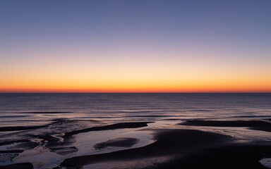 The smooth red horizon of the sea at dawn.