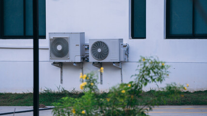 Air conditioner compressor installed on the wall of a building.