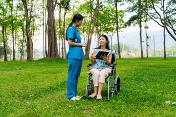 Caregiver takes elderly in wheelchair to walk in the park for health therapy, insurance concept for the elderly, happy retirement