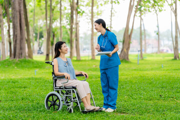 Caregiver takes elderly in wheelchair to walk in the park for health therapy, insurance concept for the elderly, happy retirement