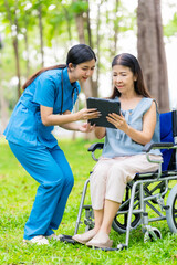 Caregiver takes elderly in wheelchair to walk in the park for health therapy, insurance concept for the elderly, happy retirement