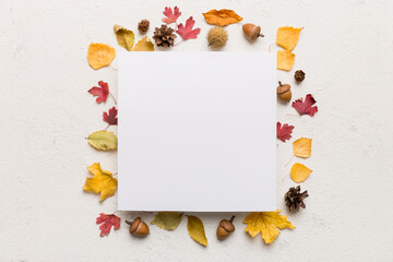 Autumn composition with paper blank and dried leaves on table. Flat lay, top view, copy space
