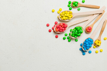 delicious colorful sweet candies on spoon on colored background . Confectionery decor top view with...