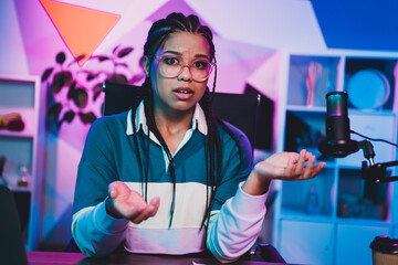 Podcaster female podcaster broadcasting with microphone in neon-lit room, demonstrating expressive...