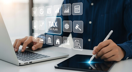 A person uses a laptop and tablet to plan taxes with digital icons representing financial concepts
