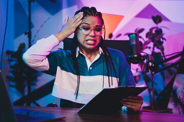 Charming Young female podcast host expressing emotion and energy in a neon-lit studio