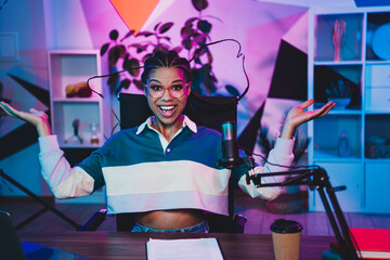 Charming professional female podcaster hosting a dynamic live media broadcast in a vibrant and...