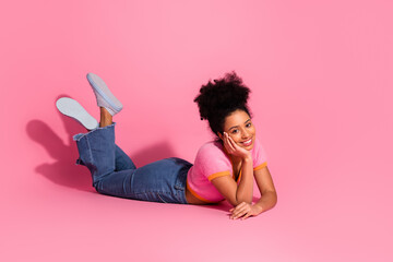 Charming young woman in casual clothing poses on pink background showcasing vibrant style and...