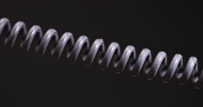 a black cable twisted in the shape of a spring for equipment, an old black cable in a rubber braid for connecting different devices