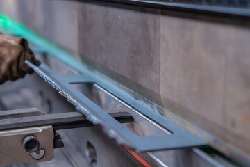 Machine de découpe laser en fonctionnement dans un atelier, réalisant des pièces industrielles métalliques avec précision.