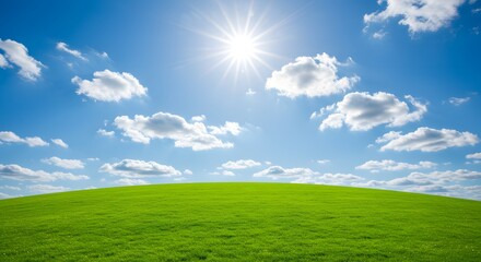 Fototapeta premium Scenic Landscape: Green Grass Hill Under Blue Sky with Sun and Clouds