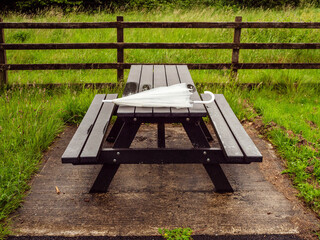 Sitting area with picnic spot on a table in a park, umbrella is laying in a top of a table. The...