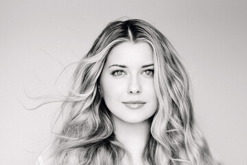 Natural beauty and hair care, blonde woman with blue eyes and elegant flowing waves, calm expression, classic elegant monochrome