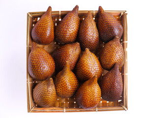 Fresh snakefruit on a bamboo plate isolated on white background, buah salak, salacca zalacca,...