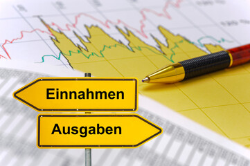 Vor einem Chart mit Kursen steht symbolisch ein Wegweiser, der in unterschiedliche Richtungen zeigt...