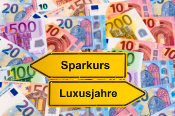Über vielen Euro Banknoten steht symbolisch ein Wegweiser, der in unterschiedliche Richtungen...