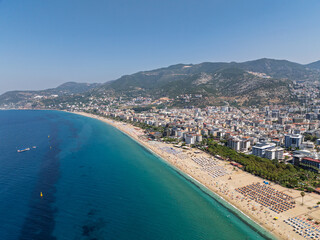 Aerial drone view of Cleopatra Beach in Alanya, Turkey. Alanya turquoise sea, sandy beach, cliffs, hills with caves, and the coastline during sunny summer day from above. Summer Mediterranean Sea.