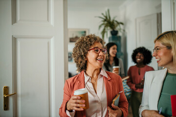 Businesswomen walking and talking during coffee break