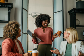 Smiling businesswomen talking during coffee break in office