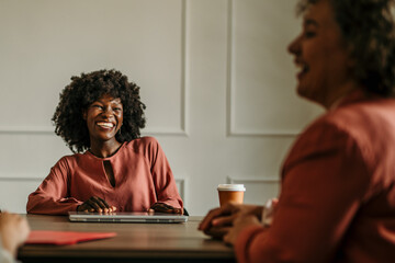Businesswomen having a meeting and smiling at the office
