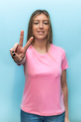 vertical Woman showing victory sign wearing pink t-shirt for Breast Cancer Awareness