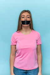 vertical Woman wearing pink t-shirt protesting with taped mouth for Breast Cancer Awareness