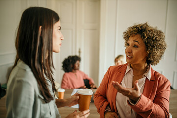 Businesswomen talking during coffee break in office meeting room