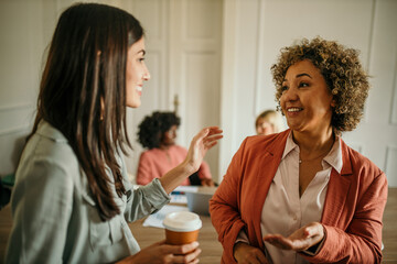 Businesswomen talking and discussing during coffee break in office