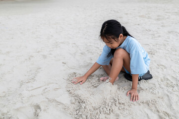 Happy children playing on the beach in summer holiday, building sandcastles and enjoying sunshine....