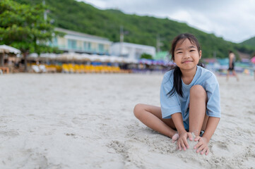 Happy children playing on the beach in summer holiday, building sandcastles and enjoying sunshine....
