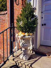 Skeletons and pumpkins on the doorstep of a house decorated for Halloween.