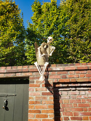 Skeleton on the fence in front of the house. Autumn holiday Halloween in America.