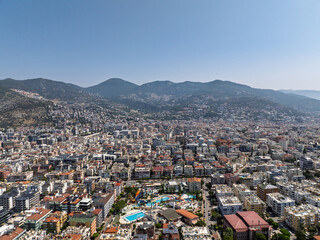 Aerial view of Alanya city in Turkey. Dense urban buildings, Mediterranean coastline, green hills...